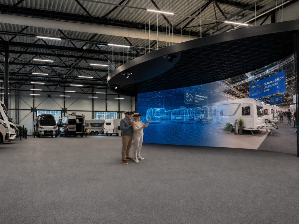 Een man en vrouw in virtual reality-brillen verkennen een tentoonstelling, zichtbaar onder de indruk van de technologie.