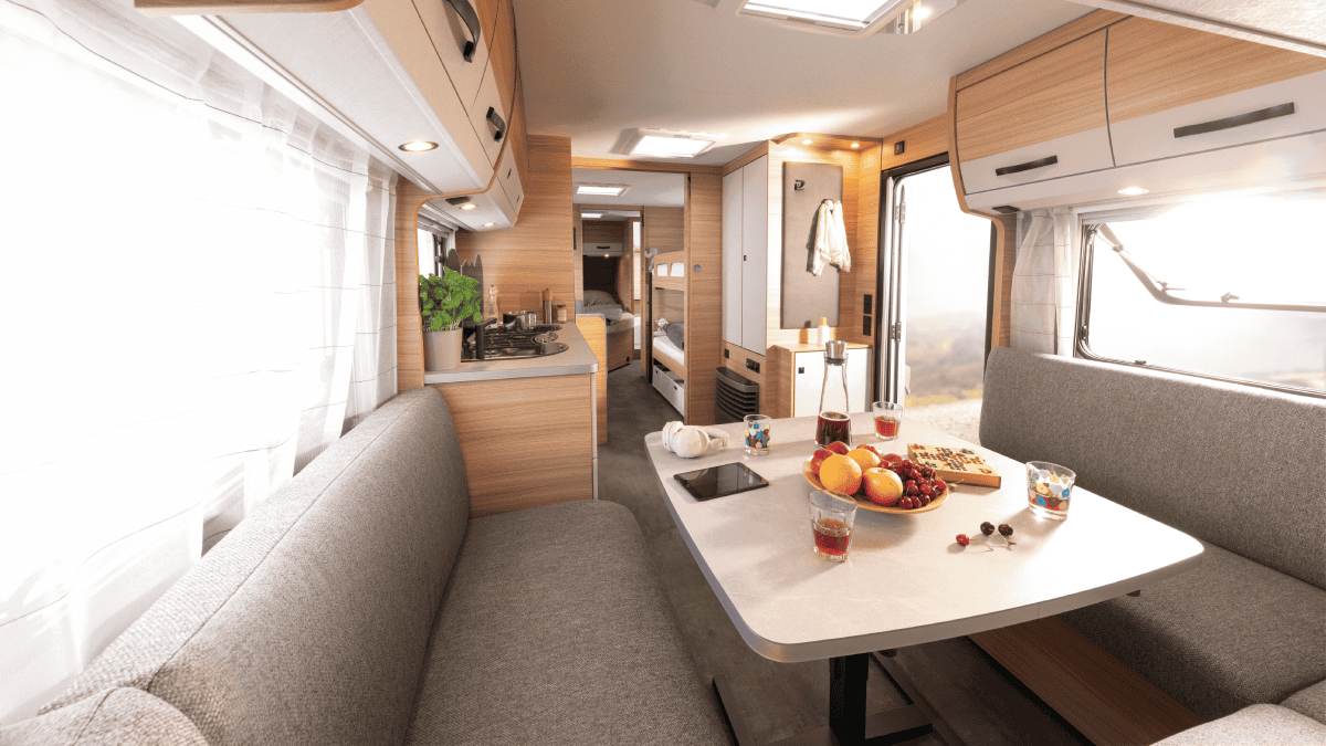 Interieur van een campervan met een keuken, zitgedeelte en bed, ingericht voor comfortabel reizen.